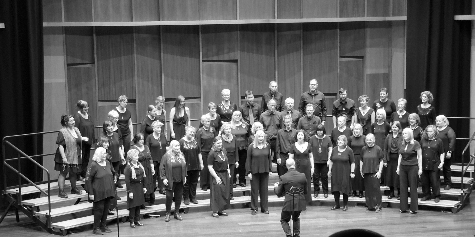 The 4th Dimension chorus singing on stage with their director in front