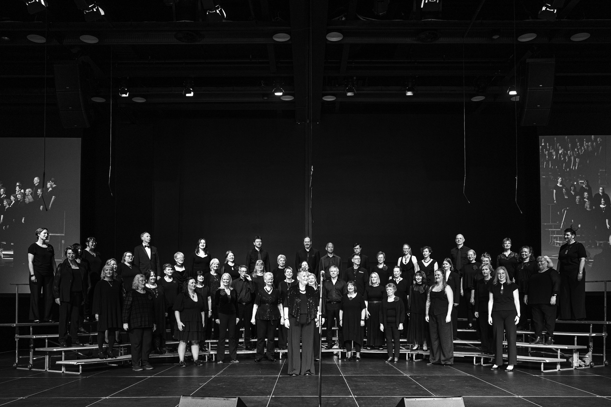 The chorus on stage at the Wellington convention, standing on risers with their director at the front