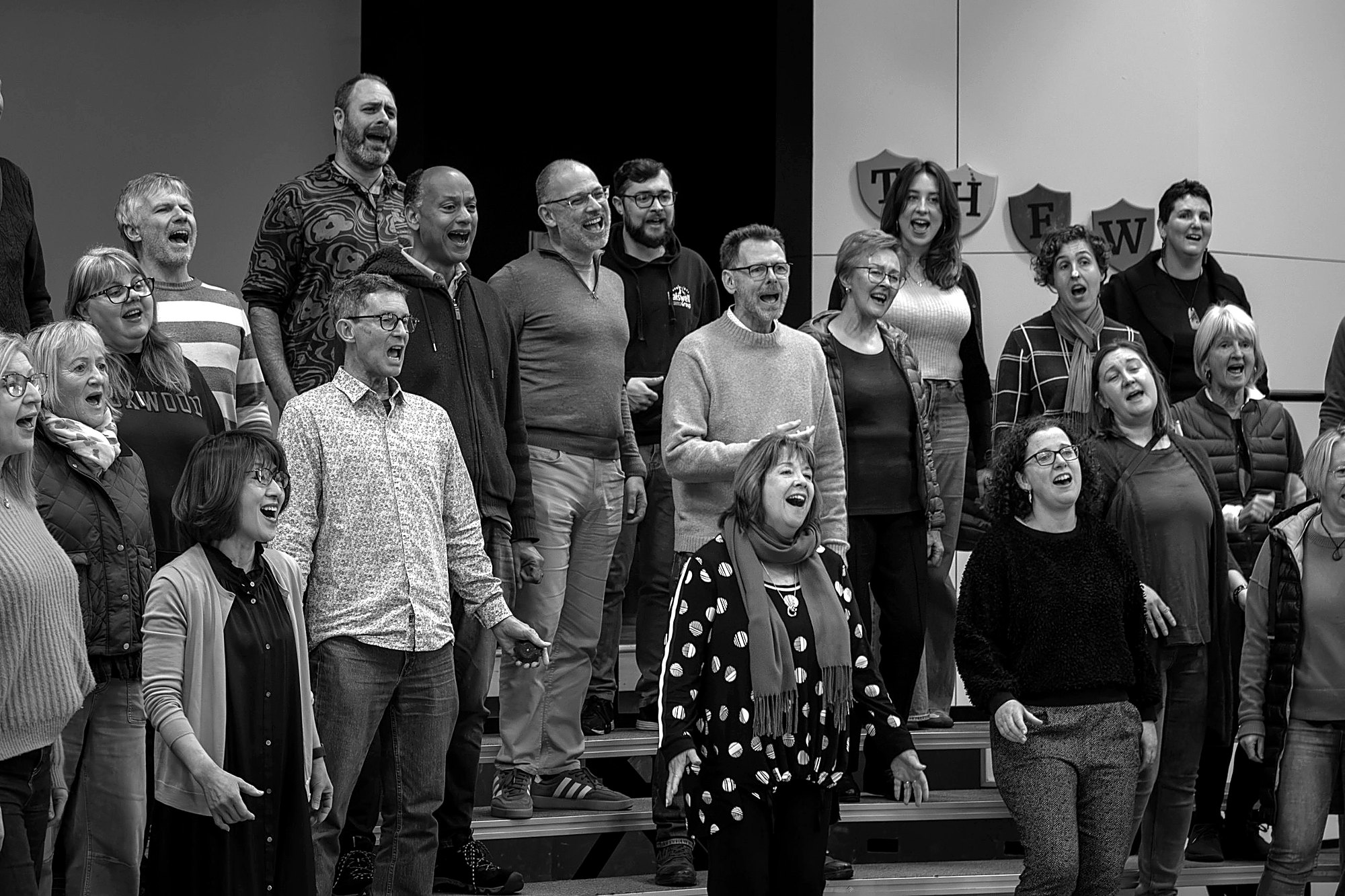 Chorus members singing together at rehearsal