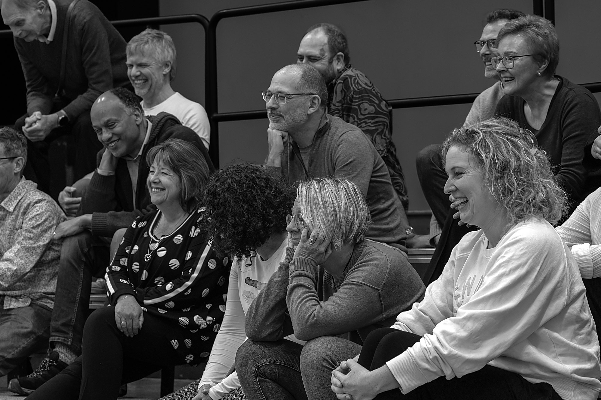 Chorus members laughing together between songs at rehearsal